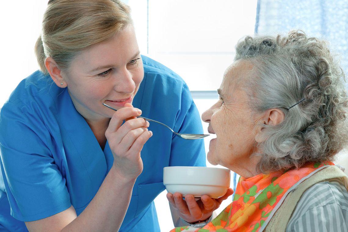 A carer helping a client with her food.