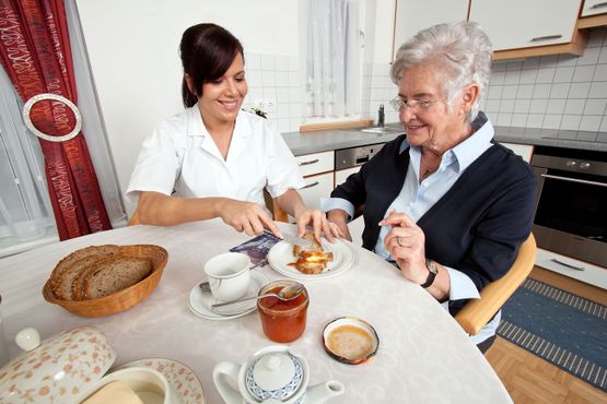 A carer helping an elderly woman 